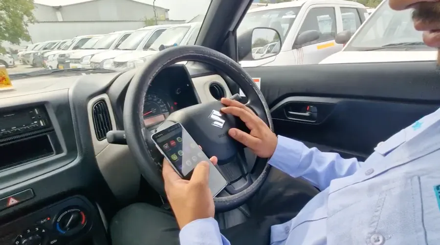 Driver holding a phone while seated at the steering wheel